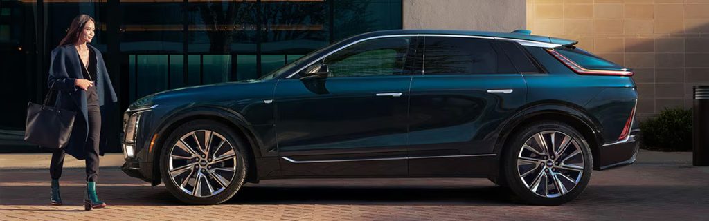 A woman walks beside the 2026 Cadillac LYRIQ electric SUV.