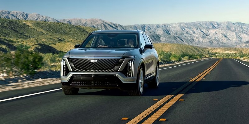Cadillac Vistiq traveling on an open mountain road with a scenic backdrop