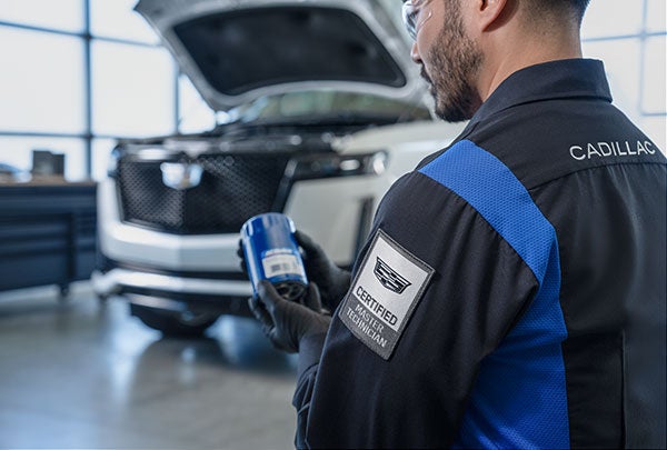 Cadillac Certified Technician changing an oil filter